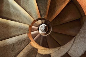 Close-up view of a spiral stone staircase showcasing intricate geometric patterns.