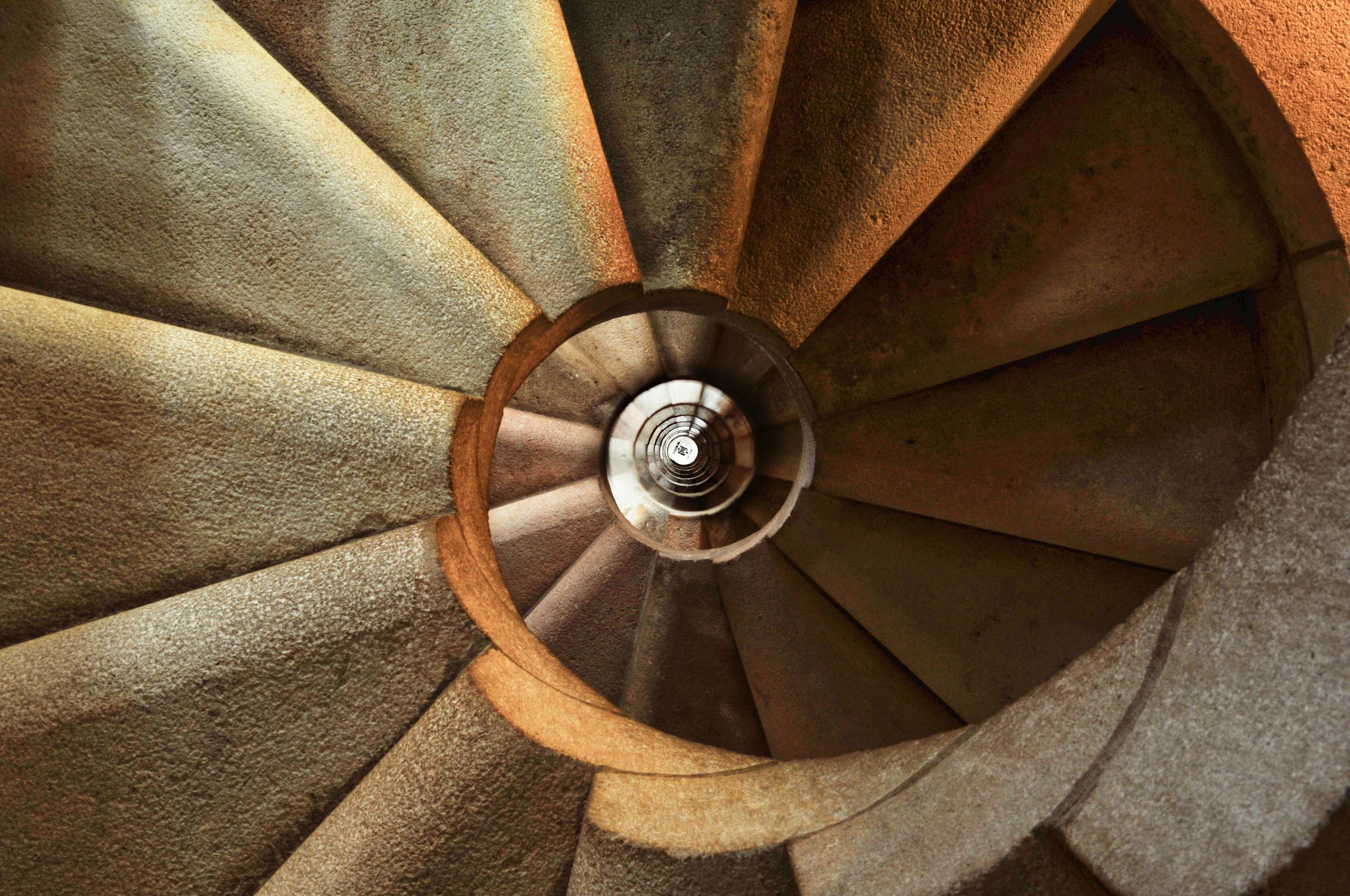 Close-up view of a spiral stone staircase showcasing intricate geometric patterns.